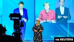 Norway's Prime Minister Erna Solberg and German Chancellor Angela Merkel (on screen) participate in the official opening of NordLink, the first power connection between Norway and Germany, in Oslo, Norway, May 27, 2021.