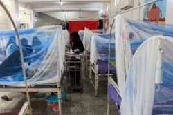 FILE - Women wait with children in a ward at a malnourishment treatment center in Yemen's northern Hajjah province, Nov. 22, 2020.