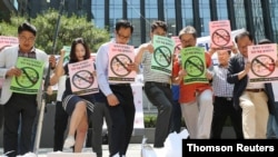 South Korean merchants step on boxes bearing logos of Japanese products during a rally to declare a boycott of Japanese goods in Seoul, South Korea, July 5, 2019.