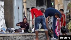 Des Algériens aident à la distribution de nourriture dans un quartier de réfugiés syriens, à Alger, le 30 juillet 2012.