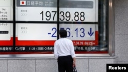 在東京商業區的一家證券行外面，有人看著日經指數（2017年8月9日）