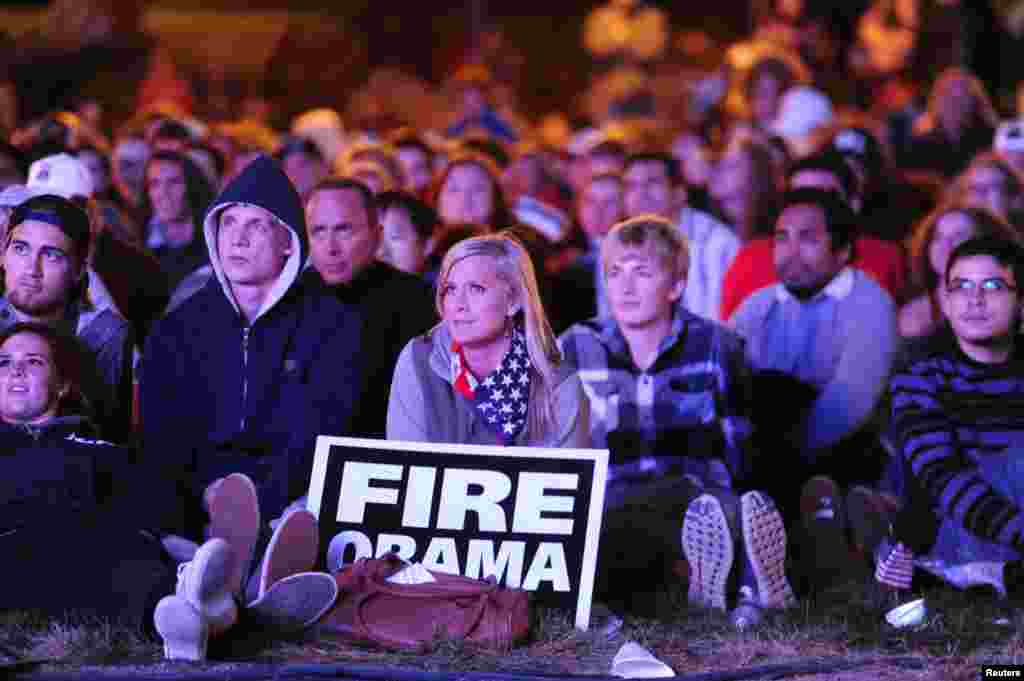 Jessica Johnston (holding sign) watches the first 2012 presidential debate on an outdoor screen at Denver University in Denver, Colorado.