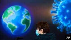 A woman wearing a face mask waits to receive a coronavirus vaccine at a COVID-19 vaccination center in Jerusalem, Monday, Jan. 4, 2021. (AP Photo/Oded Balilty)