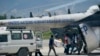 Des personnes chargent des fournitures d'urgence de Médecins Sans Frontières dans un hélicoptère des Nations Unies à destination de la ville ravagée par le séisme Les Cayes, à l'aéroport Toussaint Louverture à Port-au-Prince, Haïti, le 15 août 2021. (AP Photo/Fernando Llano)