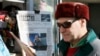 Seorang pria berjalan melewati rak yang memajang koran tentang kemenangan kembali Presiden Rusia Vladimir Putin pada 18 Maret, di Moskow, Rusia, 19 Maret 2018. Analis mengatakan Kremlin “mengekang” media di dalam Rusia dalam meliput perang di Ukraina. (Foto: Reuters)