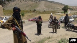 FILE - Fighters with Afghanistan's Taliban militia stand with their weapons in Ahmad Aba district on the outskirts of Gardez, the capital of Paktia province, on July 18, 2017.