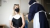 Seorang perempuan menerima suntikan vaksin COVID-19 di rumah sakit Central Middlesex di London, Inggris (foto: dok). 
