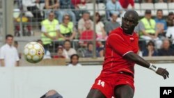 L'ancien footballeur libérien George Weah , à droite, marque un but au cours du match de son jubilé joué à Marseille, au Sud de la France, samedi 11 juin 2005. Weah a annoncé sa candidat aux prochaines élections pour le Sénat après au Liberia.