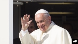 Pope Francis waves to reporters at Rome's 