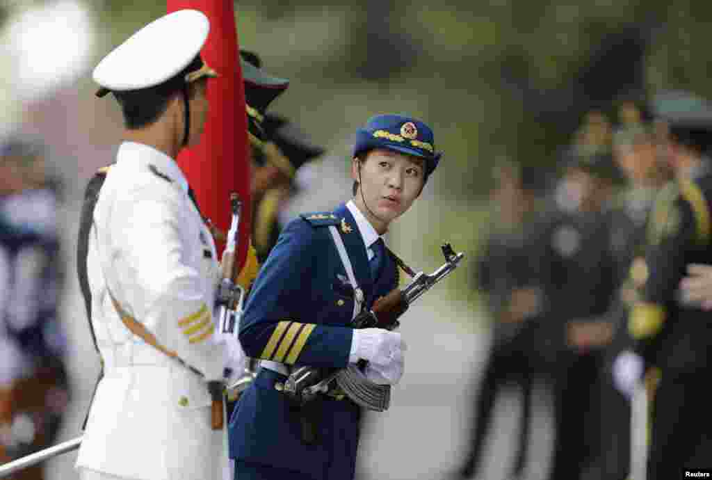 Seorang perempuan anggota pasukan kehormatan China ikut bersiap menyambut kedatangan PM Malaysia Najib Razak di luar Balai Rakyat di Beijing.
