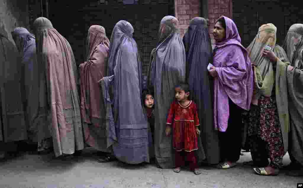 Women line up to enter a polling station and cast their ballots, on the outskirts of Islamabad, May 11, 2013.