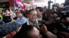 FILE - Sam Rainsy, center, leader of the opposition Cambodia National Rescue Party (CNRP), talks to journalists upon his arrival at Phnom Penh International Airport in Phnom Penh, Cambodia, Aug. 16, 2015. (AP Photo/Heng Sinith)