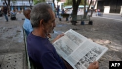 Seorang pria membaca koran di Havana, Kuba, 19 Mei 2018. 