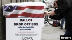 Seorang warga di Denver, Colorado, memasukkan kertas suara pada pemilu yang diadakan lebih awal (25/10). (Reuters/Rick Wilking)