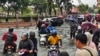 মোটর সাইকেল ও গাড়ি চালকরা কোটা ভারু শহরের কেন্দ্রস্থলে ভারী বৃষ্টিপাতের পর প্লাবিত রাস্তা অতিক্রম করছেন। কেলান্তান, মালায়েশিয়া, ২৯ নভেম্বর, ২০২৪। 