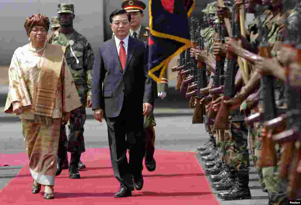Le président Hu Jintao de la Chine (c) et son homologue du Liberia, Ellen Johnson-Sirleaf (g) passent les troupes en revue à Monrovia, 1er février 2007. 