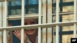 Former Ukrainian Prime Minister Yulia Tymoshenko waves to supporters from a prison window in Kyiv, Ukraine, November 4, 2011.
