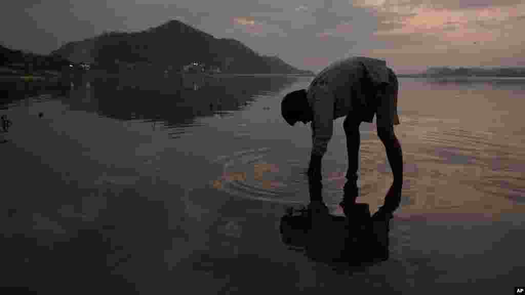 Un garçon cherche des pièces dans la rivière de Brahmaputra à la veille de la Journée mondiale de l'eau à Gauhati, en Inde, le 21 mars 2017.