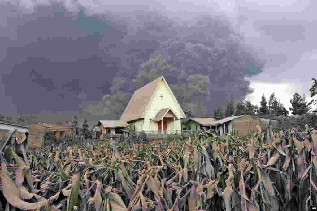 Mount Sinabung releases pyroclastic flow as a church is seen in the foreground in Sibintun, North Sumatra, Indonesia.