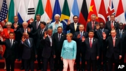 U.S. President Barack Obama, front row third from left, Chinese President Xi Jinping, second from right, and other leaders wave as they pose for a group photo session for the G-20 Summit held at the Hangzhou International Expo Center.