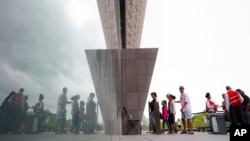 Visitors are reflected as they enter the Smithsonian National Museum of African American History and Cultural on the National Mall in Washington, May 1, 2017.