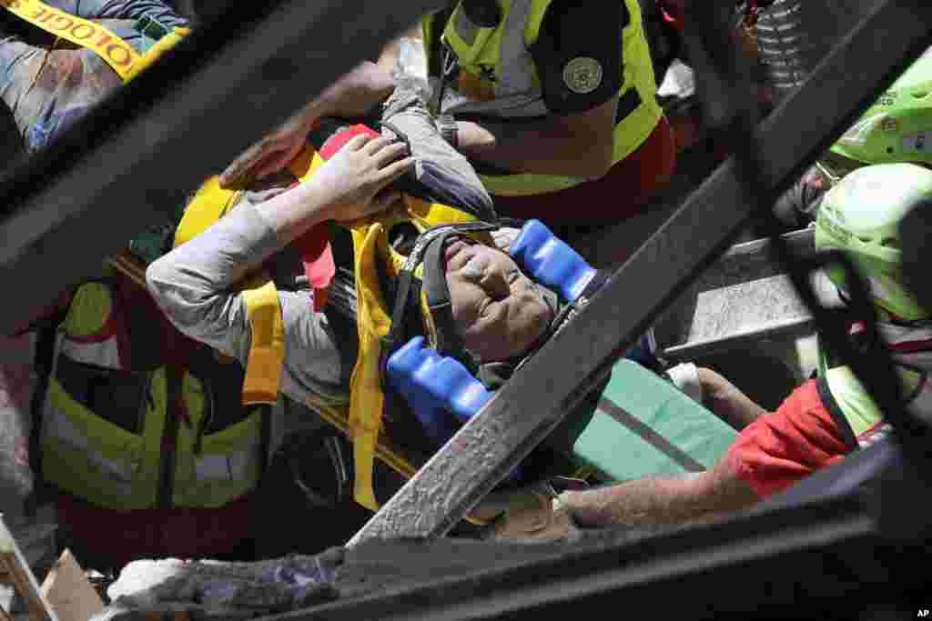 A man is rescued from the rubble of a building after an earthquake, in Accumoli, central Italy, Aug. 24, 2016. Rescue crews race to dig survivors out of the rubble, but the toll was expected to rise as crews reached homes in more remote hamlets.