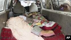 An Afghan boy peeks into a bus carrying the body of a person who was allegedly killed by a U.S. service member in Panjwai, Kandahar province south of Kabul, Afghanistan, March 11, 2012