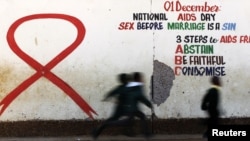 Children run past a mural painting of an Aids ribbon at a school in Khutsong Township, 74 km (46 miles) west of Johannesburg, August 22, 2011. 