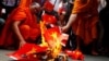 Cambodian protesters burn mock Vietnamese flags during a protest at a blocked main street in front of Vietnamese Embassy in Phnom Penh, Cambodia, Wednesday, Oct. 8, 2014. 