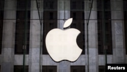 Un logo Apple est suspendu au-dessus de l'entrée de l'Apple Store sur la 5e Avenue dans le quartier de Manhattan à New York, le 21 juillet 2015.