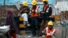 FILE - Laborers eat during a break from their work at the site of a commercial building under construction in Noida, on the outskirts of New Delhi, Dec. 13, 2013.