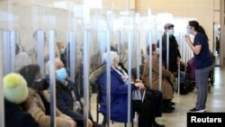 Seniors sit in a waiting room after receiving their vaccine against the coronavirus as Quebec begins vaccinations for seniors over 85 years old in Laval, Quebec, Canada, Feb. 25, 2021.