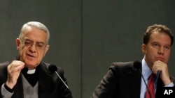 Le porte-parole du Vatican, le père Federico Lombardi, à gauche, et le conseiller en communication du Vatican Greg Burke présentent la page Twitter du Pape Benoît XVI aux journalistes à la salle de presse du Vatican, 3 décembre 2012. (AP Photo / Gregorio Borgia)