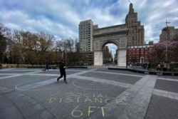 Gente camina alrededor del parque Washington Square en Nueva York el 22 de marzo de 2020, mientras la pandemia de COVID-19 continúa afectando la ciudad.