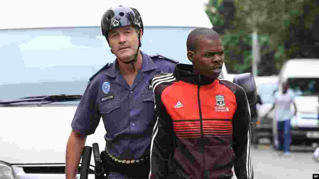 Un jeune homme est arrêté pour des raisons inconnues au cours d’une marche contre la xénophobie à Durban, Afrique du Sud, jeudi 16 avril 2015.