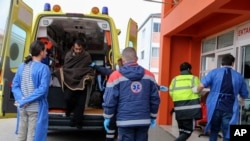 Radnici hitne pomoći u grčkom lučkom gradu Prevezi pomažu preživjelom poslije nesreće u Egejskom moru. 