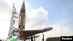 Sebuah drone terlihat berada di samping sebuah rudal yang dipamerkan dalam acara peringatan ke-44 tahun sejak Revolusi Islam di Iran terjadi. Acara berlangsung di Teheran, pada 11 Februari 2023. (Foto: Majid Asgaripour/WANA (West Asia News Agency) via Reuters)