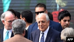FILE - U.S. special envoy for Afghanistan Zalmay Khalilzad (C) arrives for a ceremony at the Presidential Palace in Kabul, March 9, 2020.