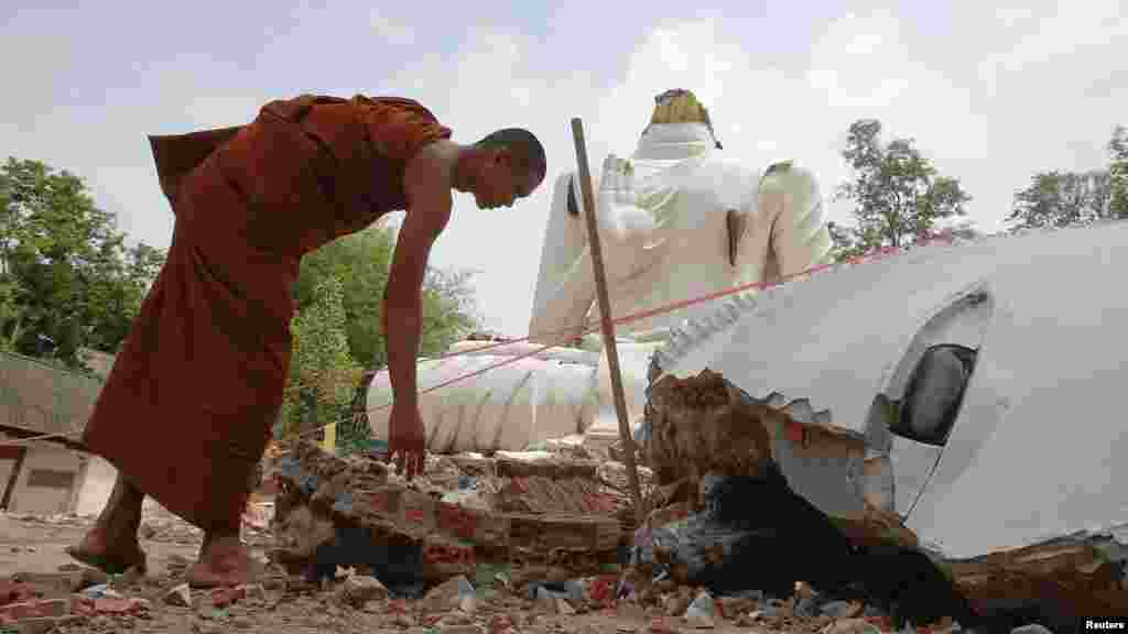 A Buddhist monk checks a statue of Buddha that was damaged by an earthquake at the Udomwaree temple in Chiang Rai, northern Thailand, May 6, 2014.