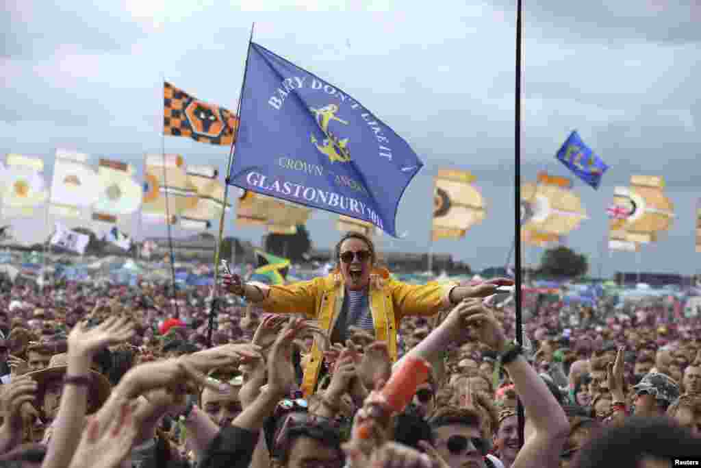 Para pengunjung festival bersorak di depan panggung "Other Stage" di Worthy Farm di Somerset, Britania Raya, pada Festival Glastonbury. 