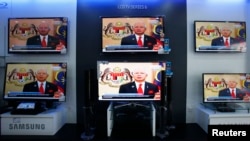 Malaysia's Prime Minister Najib Razak is seen on TV during a news bulletin as he announces the dissolution of parliament, at an electronics shop in Kuala Lumpur, April 3, 2013.