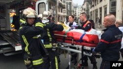 Firefighters carry an injured man on a stretcher in front of the offices of the French satirical newspaper Charlie Hebdo in Paris after armed gunmen stormed the offices leaving at least one dead, Jan. 7, 2015.