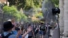 ARCHIVO: Turistas se refrescan frente a un ventilador eléctrico en la entrada del Coliseo de Roma el 18 de julio de 2023.