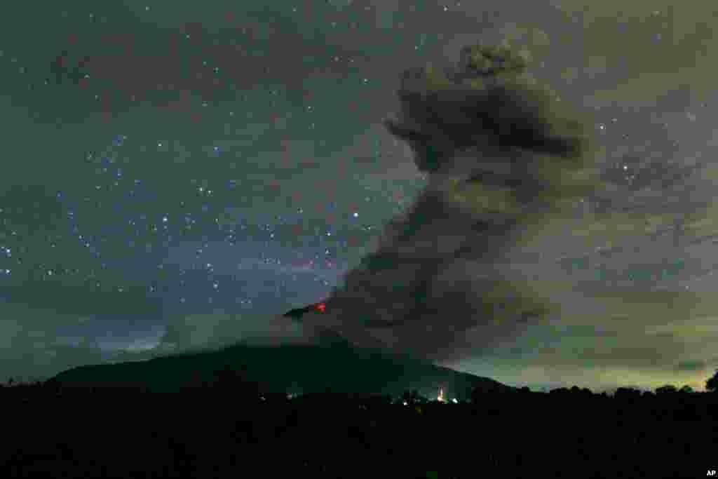 Gunung Sinabung memuntahkan abu vulkanik ke udara diambil dari desa Tiga Pancur, Kabupaten Karo, Sumatra Utara, Minggu malam (24/11).