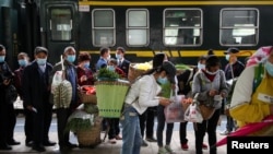A pesar del levantamiento de muchas restricciones por el coronavirus en China, los viajeros tienen que presentar códigos de salud a las autoridades, como en esta estación de la procinvia de Guizhou el 16 de abril de 2020.