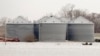 Utility workers travel by boat past grain bins in the flooded town of Pacific Junction, Iowa, April 3, 2019. 