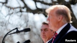 El presidente de Brasil, Jair Bolsonaro, escucha al presidente de los Estados Unidos, Donald Trump, durante una conferencia de prensa conjunta en el Jardín de las Rosas de la Casa Blanca en Washington, EE.UU., en 2019.