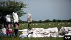 Des femmes portent des sacs de nourriture distribués à Padding, dans le Soudan du Sud, le 3 juillet 2017.