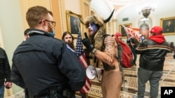 Para pendukung Presiden Trump dihadang oleh anggota polisi Gedung Capitol di luar Ruangan Senator di Gedung Senat, di Washington, 6 Januari 2021. 