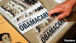 Un miembro del Tea Party prepara un panfleto sobre "El impacto del Obamacare" en Littleton, New Hampshire, en octubre de 2012.